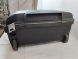 a black suitcase sitting on top of a white sheet