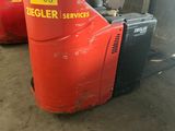 a red forklift with a yellow tag on it in a garage