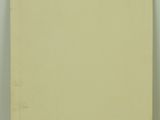 a yellow book sitting on top of a table next to a white wall