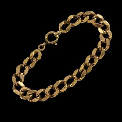 un bracelet en or composé de maillons ovales sur fond noir