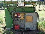 a small green building with a red canister on the side of it