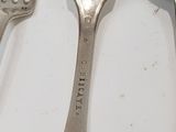 two spoons and a fork sitting on a table