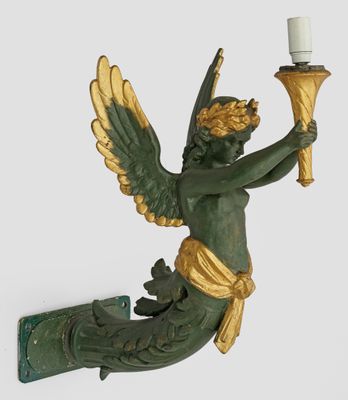 a statue of an angel holding a candle on a wall
