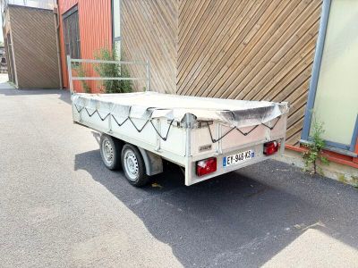 une remorque blanche garée devant un immeuble