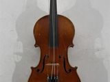 un vieux violon accroché au mur, avec l'ombre d'une personne derrière lui