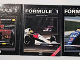 three books of formula racing on display on a white surface