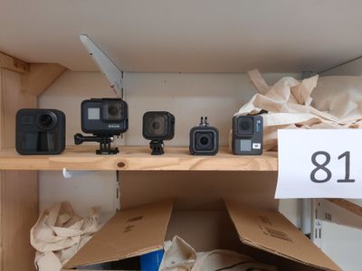 de nombreux appareils photo posés sur une étagère dans une pièce