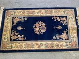 une image représentant un tapis bleu orné d'une bordure dorée et de fleurs