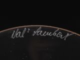 a close up of a plate with writing on it on a black surface