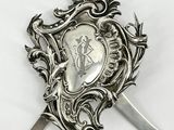 une assiette en argent sur laquelle sont représentés un couteau et un bouclier