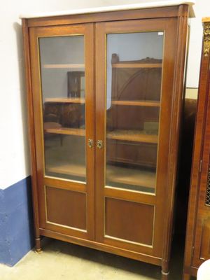 un meuble en bois avec des portes en verre dans le coin d'une pièce