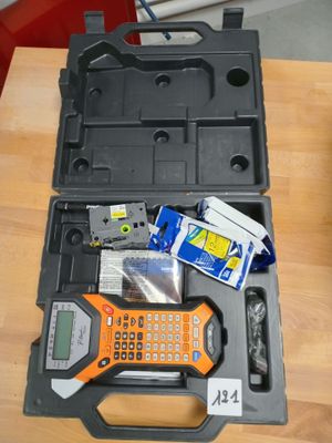 une boîte à outils contenant une calculatrice et d'autres objets, posée sur une table