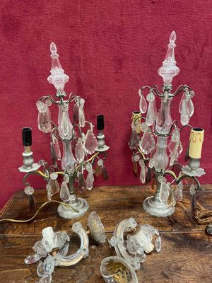 pair of antique crystal candle holders on a wooden table with a red background