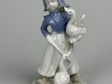 une figurine représentant une petite fille tenant un canard et une oie