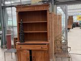 a wooden cabinet and a chair in a room