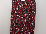 a red and black floral skirt hanging on a hanger