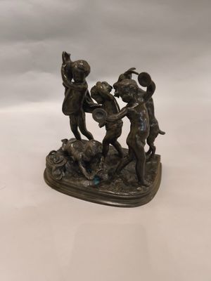 statue en bronze représentant trois enfants jouant avec un ballon sur une table