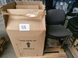 une boîte en carton posée sur une palette, à côté d'une chaise