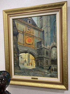 une photo d'un tableau accroché au mur à côté d'un vase
