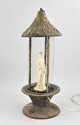 une image représentant une lampe surmontée d'une statue