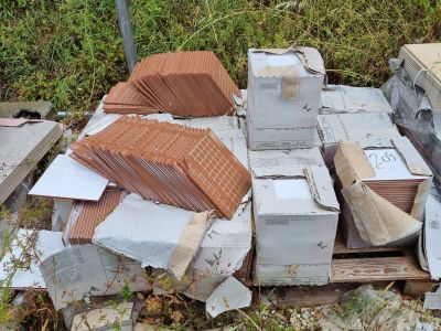 une pile de cartons posée sur une palette dans l'herbe