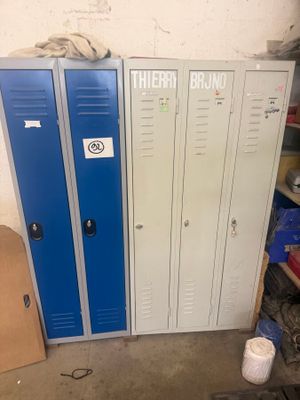 two blue lockers in a room with boxes on the floor