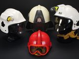 several different types of helmets are lined up on a black surface