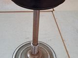 a black stool sitting on top of a tile floor