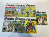 six french comic books on a white surface