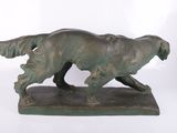 bronze statue of a dog running on a base on a white background