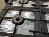 une plaque de cuisson en métal sur laquelle est posé un brûleur en métal