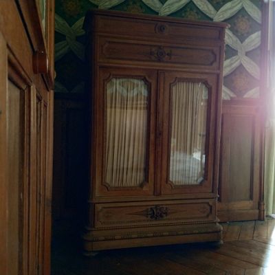 un grand meuble en bois dans le coin d'une pièce