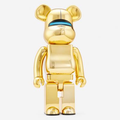 a gold bear that is standing in front of a white background