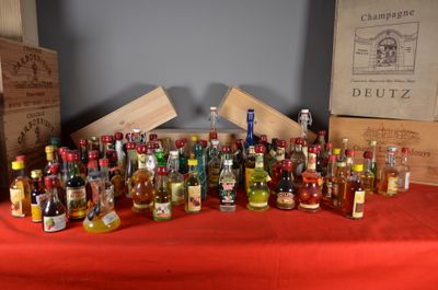 many bottles of alcohol sitting on a table with a red table cloth