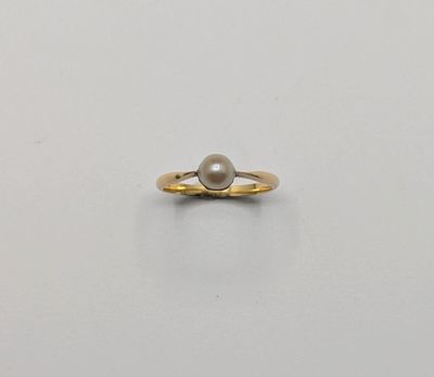 une bague en or avec une perle au centre