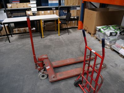 un diable rouge posé au milieu d'un entrepôt