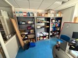 a room with a desk, shelves, and a computer