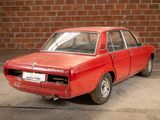 a red car that is parked in front of a brick wall