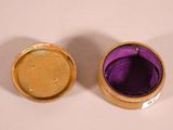two gold and purple boxes are sitting on a white surface