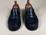 a close up of a pair of black shoes on a white surface