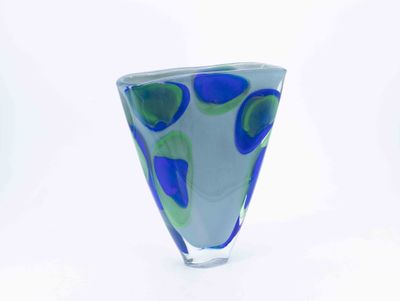 a blue and green vase sitting on a white surface