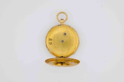 a close up of a gold pocket watch on a white surface
