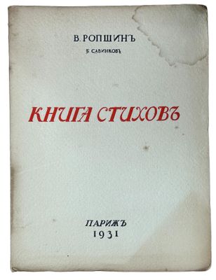 a white book with red writing on it sitting on top of a table