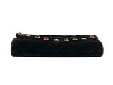 a black quilted purse with multi colored stones on it