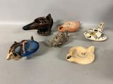several small figurines of birds are sitting on a white surface
