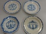 four blue and white plates with designs on them sitting on a table
