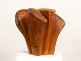 a wooden sculpture on a white pedestal with a white background