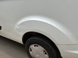 a white van parked in a parking lot next to a building