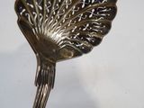 a silver spoon with a bird on it on a white surface
