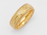 a close up of a gold ring with a diamond in the center